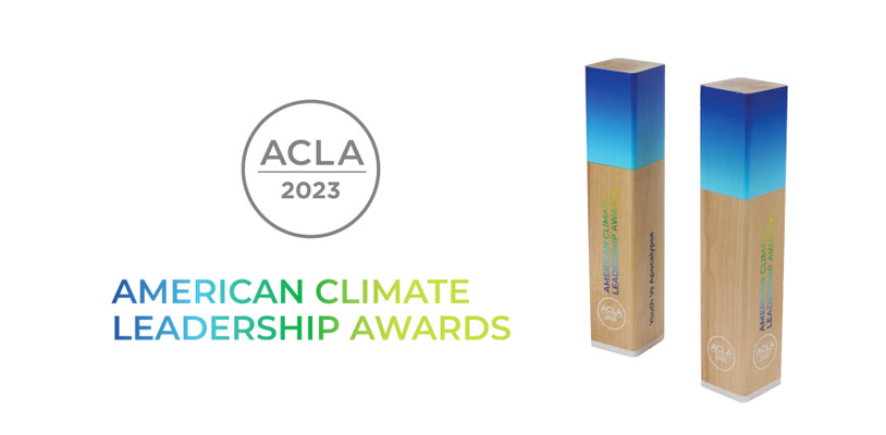 A circle containing text that reads "ACLA 2023." The text logo below the circle reads “American Climate Leadership Awards” in all capital letters and with a blue-to-green gradient color. To the right of the logo are two American Climate Leadership Awards trophies shaped like rectangular prisms.
